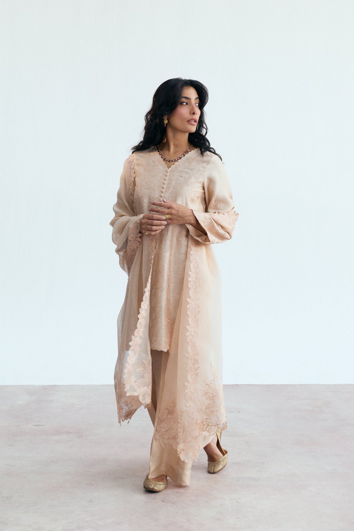 Cutwork detailing on hem and side seams of a peachy pink rayon kameez
