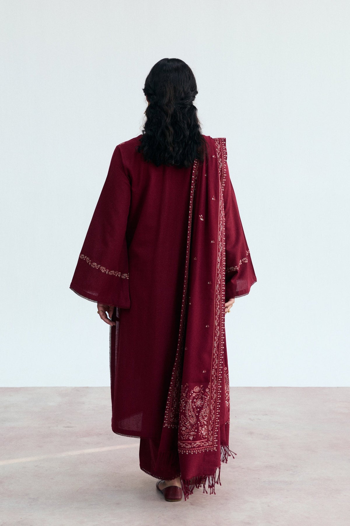 Full-length view of Mannam Garnet Set — deep red khaddar kameez with straight trousers and embroidered tassel shawl