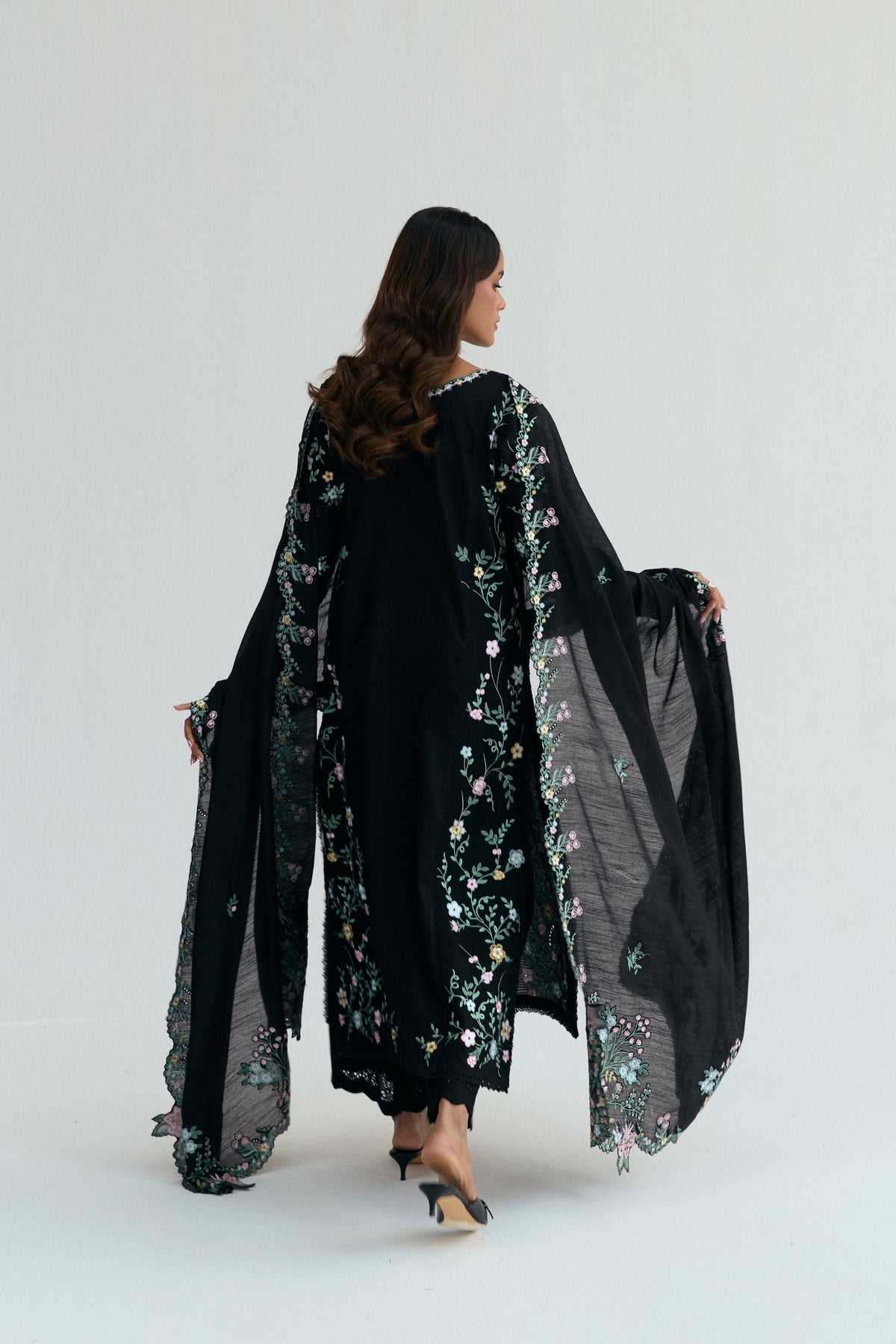 Back view showing cascading floral embroidery across full length