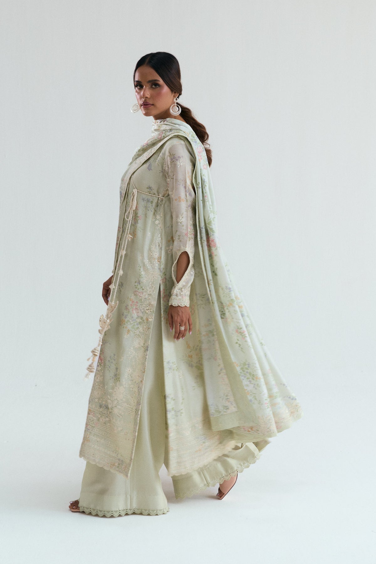 Handcrafted tassel and printed accent detail on a premium angrakha Pakistani suit in soft green-beige