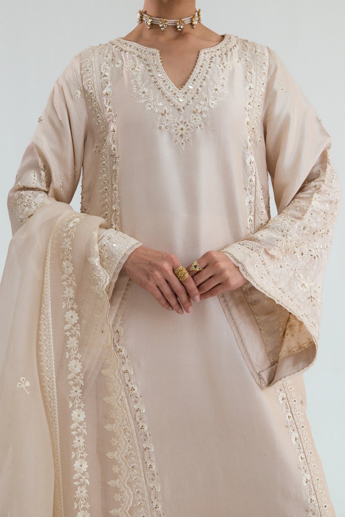 Close-up of hand-embroidered mirror work on a premium silk kameez from a Pakistani designer collection