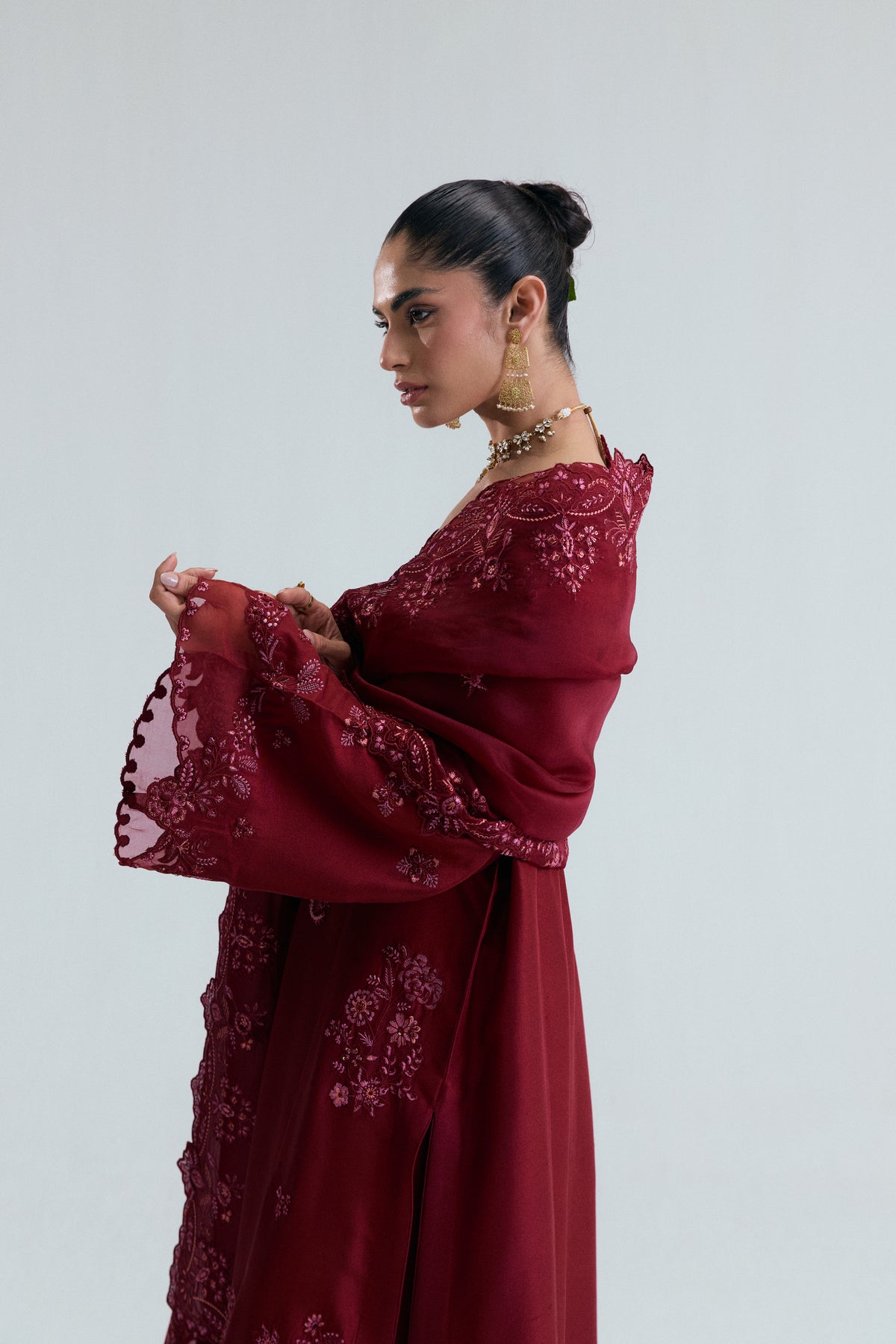 Side view of Mannam Cranberry maroon raw silk suit with side-slit trousers and embroidered organza dupatta