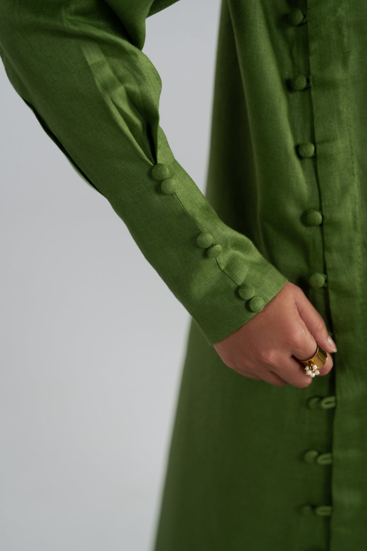 Green coat with button details on the kameez and cuffs.
