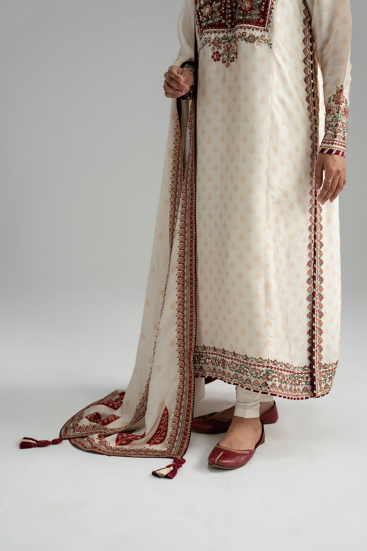 Red applique neckline close-up — resham and sequin embroidery on ivory kameez