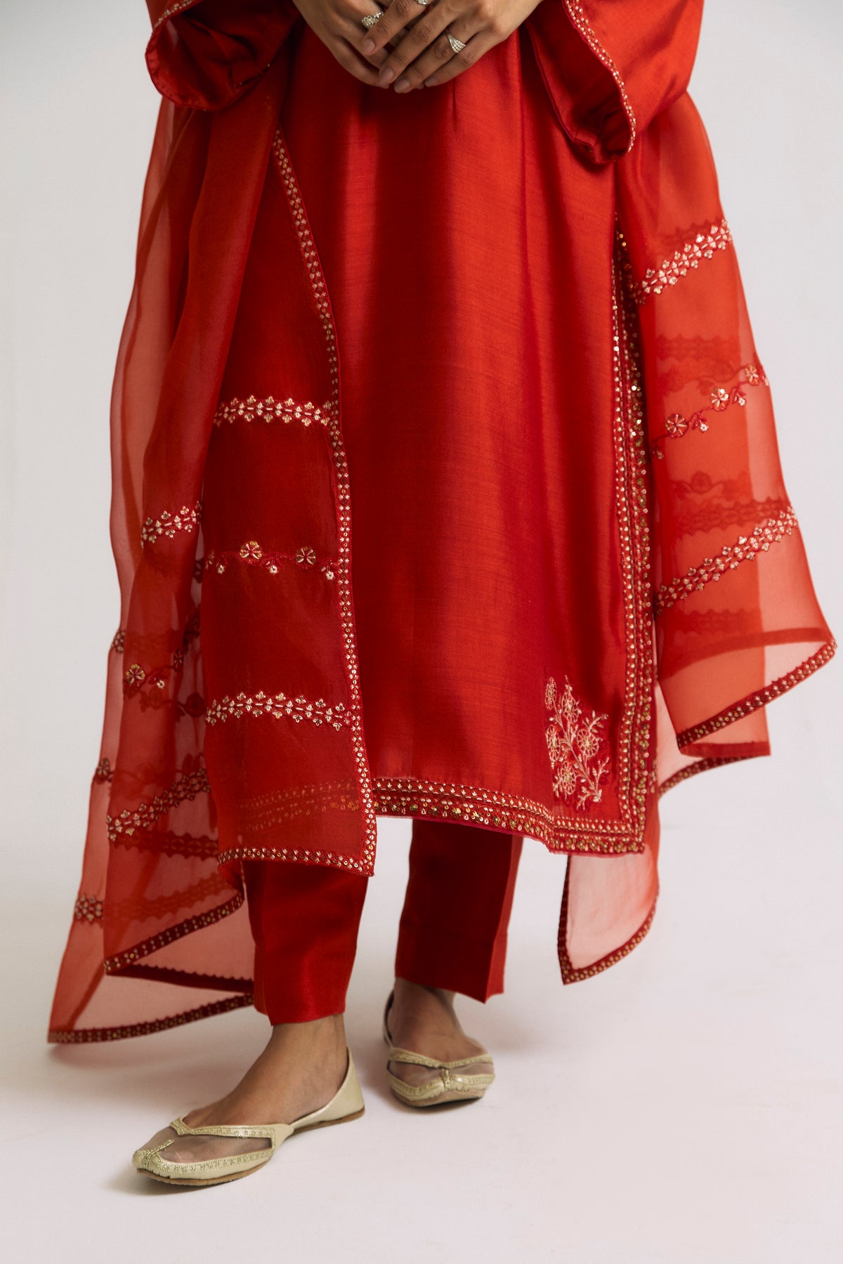 Floral embroidery at hem — artisanal hand-stitched detail on burnt orange silk kameez