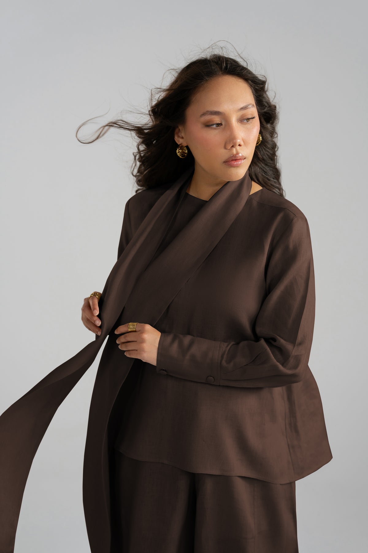 Linen dark brown draped wrap shirt and matching wide-leg trousers, scarf detail in motion.
