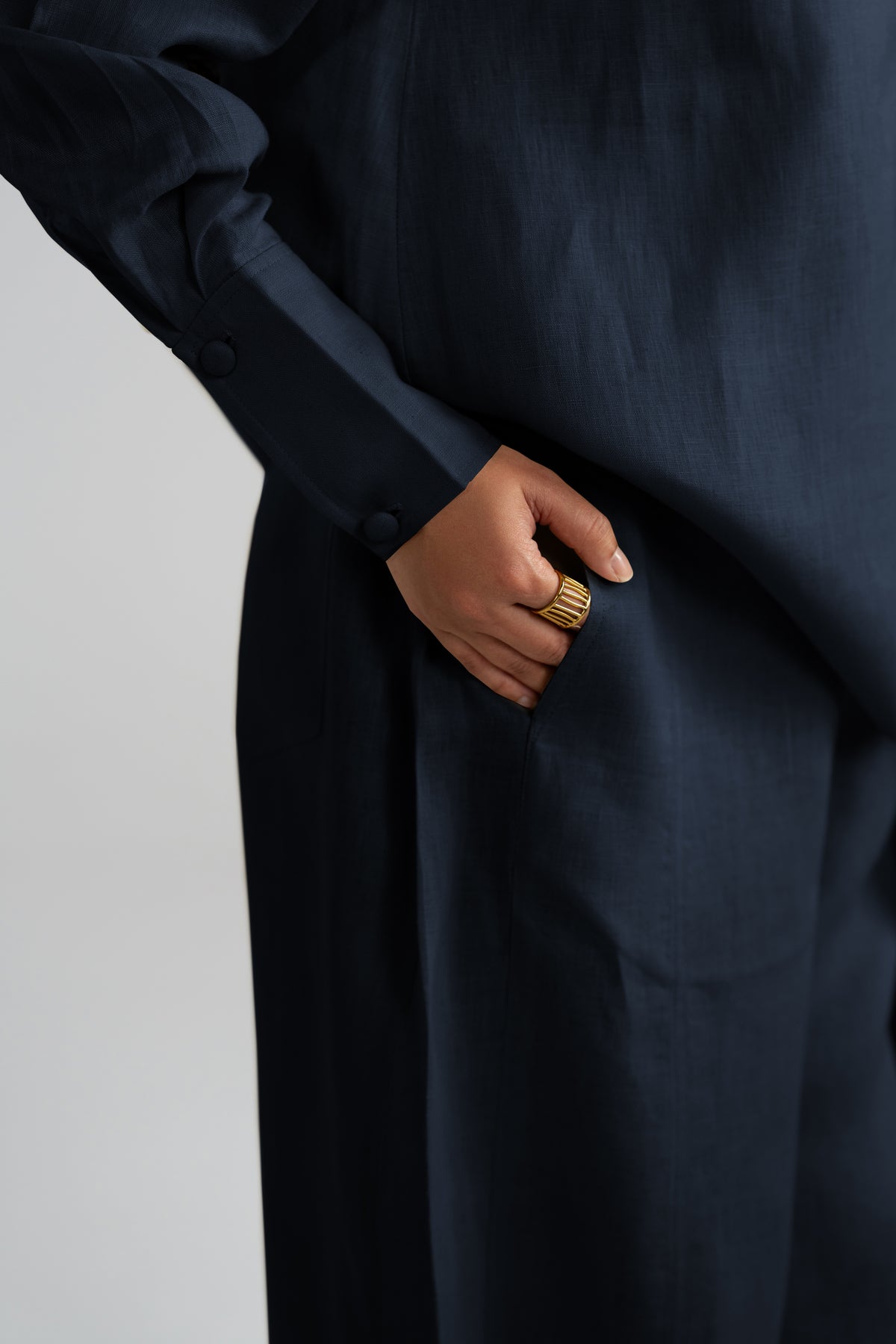 Close-up shot of the Cove Set in navy blue highlighting the gathered sleeves, fabric button cuffs and pure linen texture.