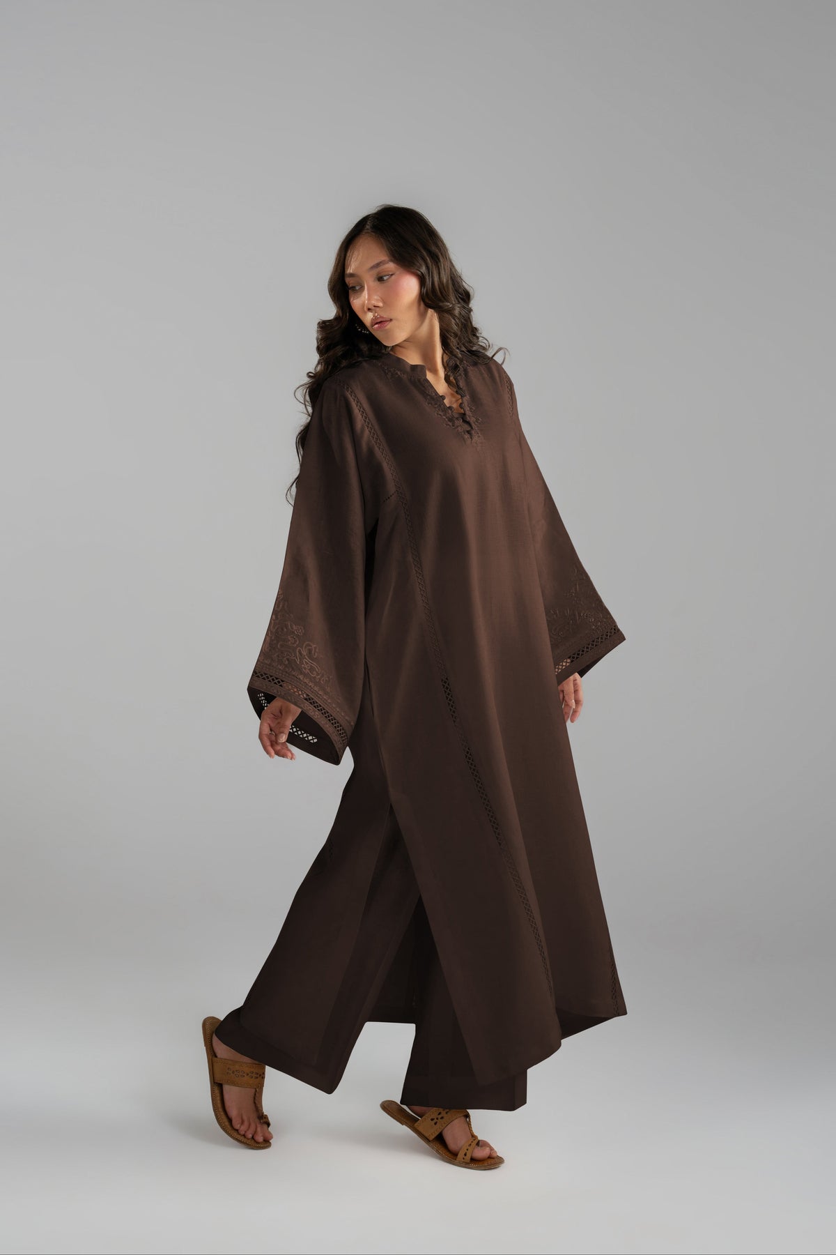 Model walking in the Maple Set, brown tunic and wide-hem trousers in motion
