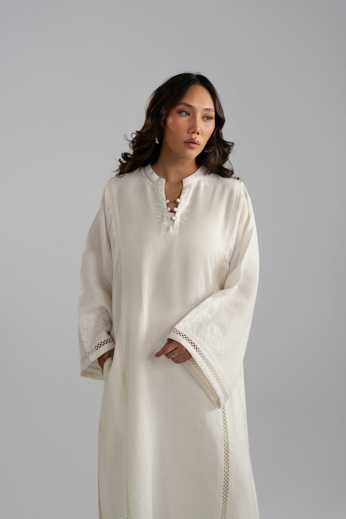 Close-up of wide-hem white linen trousers paired with embroidered linen kameez