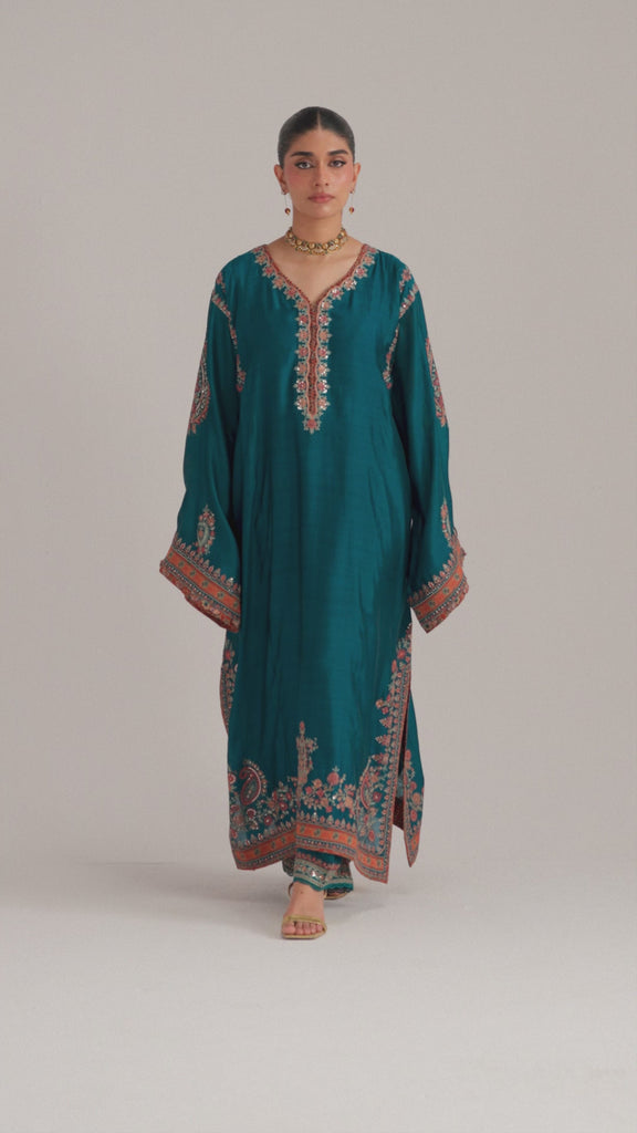 The Afroz Set is a teal blue pure silk Pakistani phiran featuring Kashmiri-inspired embroidery, ajrak print accents, tassel sleeves, and pockets